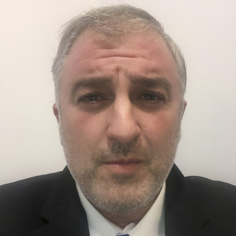 Dennis Mantjos, Vice President of Rocky Zapata Safety Consultants, wearing a suit and tie, with a neutral expression against a plain background.