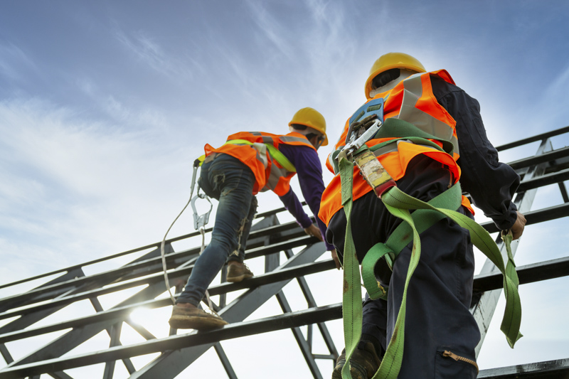 Safety body construction, Working at height equipment. Fall arre Construction workers in safety gear climbing a metal structure, emphasizing safety practices and hazard awareness in industrial settings.